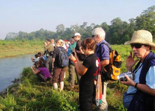 a group of people standing next to a river at Horizon Homes - Sauraha Chitwan in Sauraha