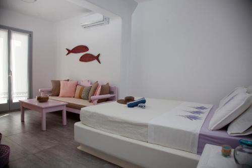 een slaapkamer met een groot bed en een bank bij Paros Melodia Apartments in Logaras