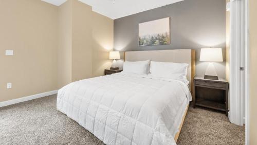 a bedroom with a large white bed with two lamps at Landing Modern Apartment with Amazing Amenities (ID7864X05) in Memphis