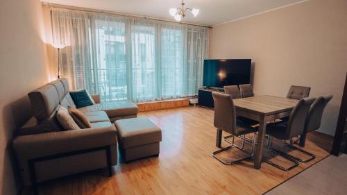 a living room with a couch a table and a television at Apartament Stylowy - Zeta Park in Ustroń