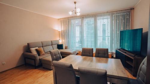 a living room with a table and a couch at Apartament Stylowy - Zeta Park in Ustroń