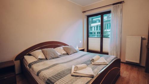 a bedroom with a bed with two towels on it at Apartament Stylowy - Zeta Park in Ustroń