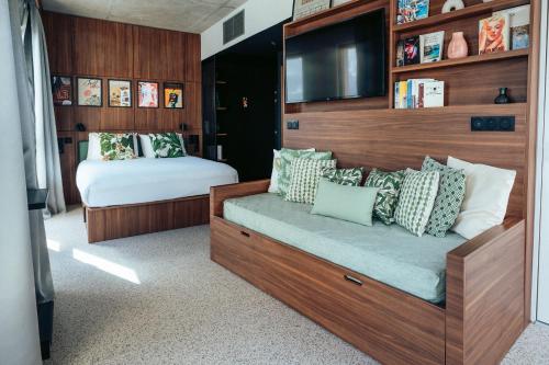 a bedroom with a bed and a tv on the wall at JOST Hôtel Bordeaux Centre Gare Saint Jean in Bordeaux