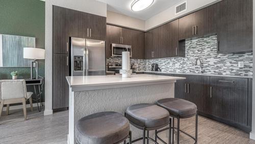 Landing Modern Apartment with Amazing Amenities (ID8083X42) في Fort Myers Villas: مطبخ مع كونتر وكراسي في غرفة