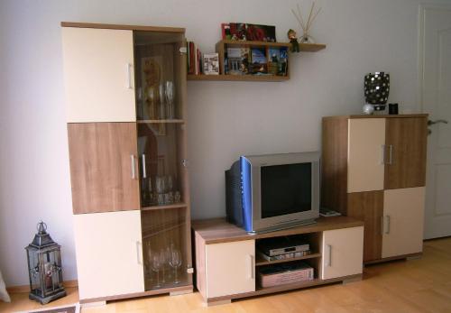 ein Wohnzimmer mit einem TV und einem Entertainment-Center in der Unterkunft Ferienwohnung Kottmarsdorf in Kottmarsdorf