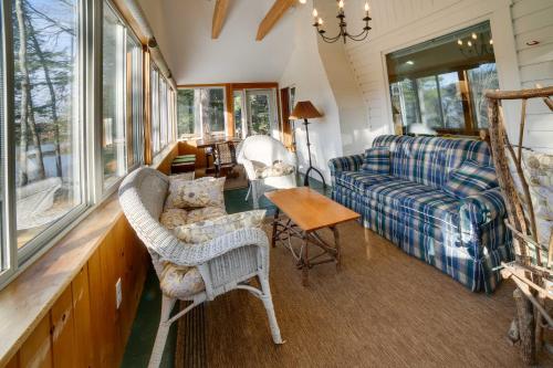 een woonkamer met een bank, stoelen en ramen bij Lakefront Bradford Cottage with Dock, Near Skiing! in Bradford