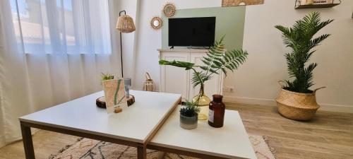 un salon avec une table blanche et des plantes en pot dans l'établissement Résidence de Mâcon, à Mâcon