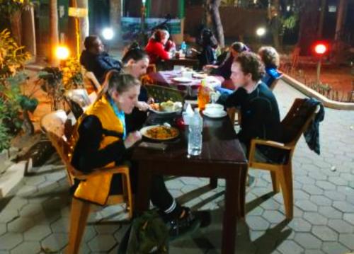 a group of people sitting at a table eating food at Hotel Horizon Homes - Sauraha Chitwan in Sauraha