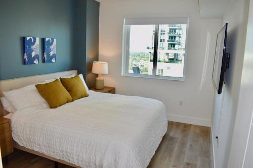 1 dormitorio con cama blanca y ventana en Landing Modern Apartment with Amazing Amenities (ID746) en Fort Lauderdale