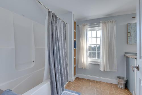 a bathroom with a tub and a window at Downtown Ogunquit Home 1 Mi to Beach! in Ogunquit