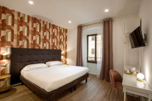 ein Schlafzimmer mit einem großen Bett und einem Fenster in der Unterkunft Amalia Suites by Remember Rome in Rom