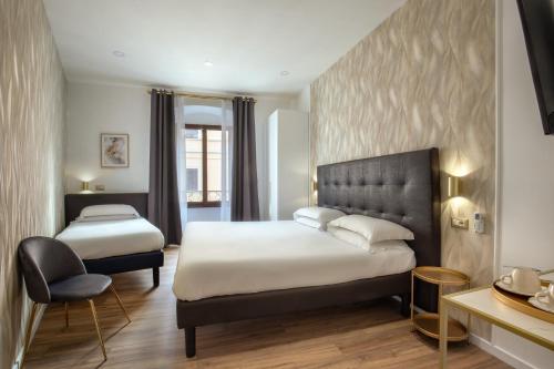 ein Hotelzimmer mit 2 Betten und einem Stuhl in der Unterkunft Amalia Suites by Remember Rome in Rom