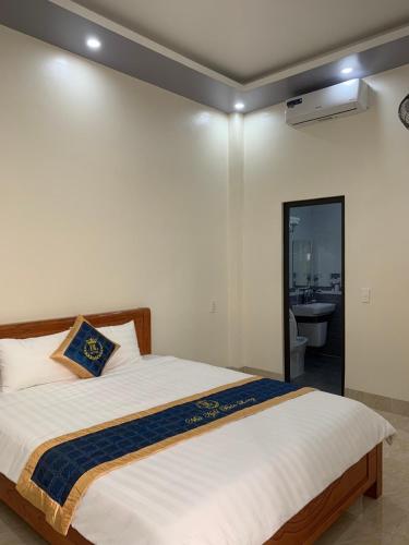 een slaapkamer met een groot bed en een badkamer bij Bảo Long Motel in Dồng Văn