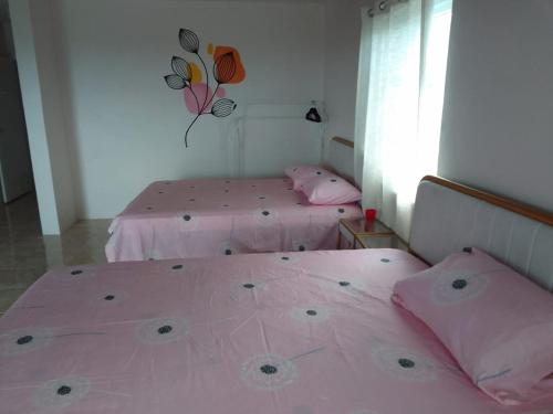 two beds in a room with pink sheets and pillows at Belle Air Seaview ( 2 Bdrm -2 Bath) in Runaway Bay