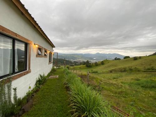 a house with a view of a green field at La Casita de Charo 2 in Constanza