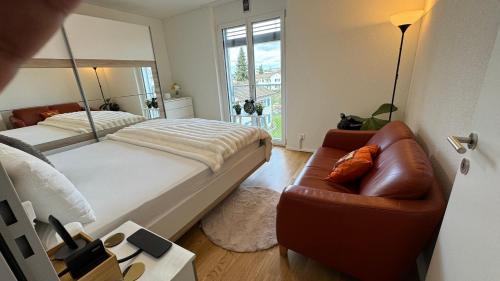 a bedroom with a bed and a couch and a chair at VK - Air Conditioned - Luxury - Home Stay in Kloten