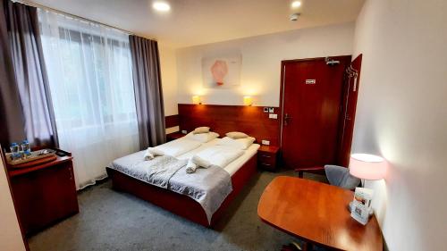a hotel room with a bed and a desk at Malachit Karpacz SPA Hotel in Karpacz