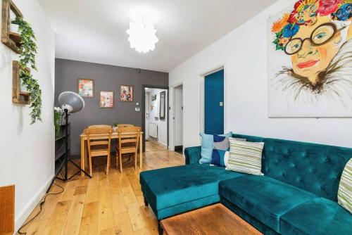 a living room with a blue couch and a table at City-Accessible 1-Bed Apartment in Bethnal Green in London