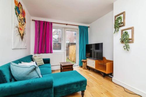 sala de estar con sofá azul y TV en 1-Bed Apartment in Bethnal Green, en Londres
