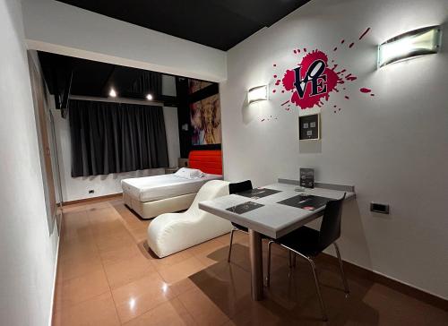 a living room with a couch and a table and a bed at Zouk Hotel in Alcalá de Henares