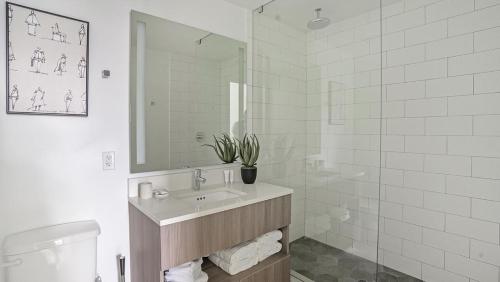 La salle de bains blanche est pourvue d'un lavabo et d'une douche. dans l'établissement Landing - Modern Apartment with Amazing Amenities (ID1401X723), à Fort Lauderdale