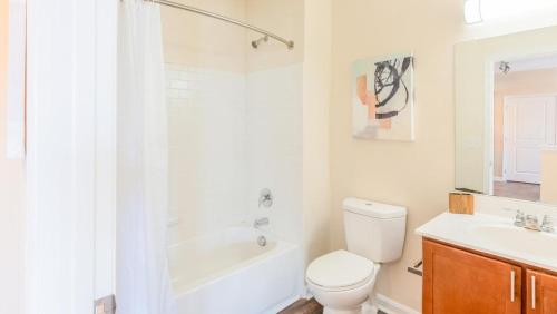 een witte badkamer met een toilet en een wastafel bij Landing Modern Apartment with Amazing Amenities (ID2284) in Ellicott City