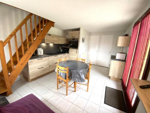 une petite cuisine avec une table et un escalier dans l'établissement Maisonnette 4 pers - Piscine commune - plage à 500 m- ARGANE, à Guidel-Plage