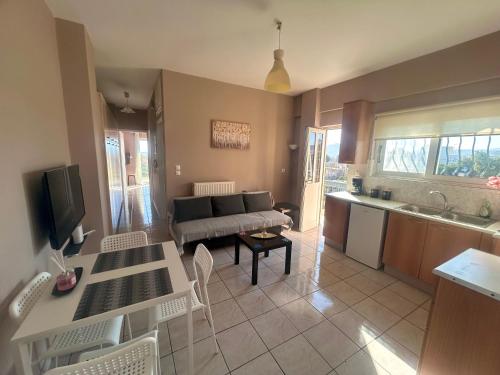 een keuken en een woonkamer met een bank en een tafel bij AKTIS apartment near airport in Artemida