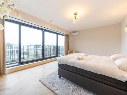 ein Schlafzimmer mit einem Bett und einem großen Fenster in der Unterkunft Beautiful water villa near Harderwijk in Zeewolde