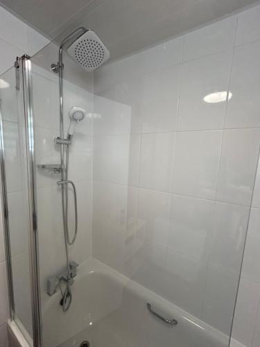 a bathroom with a shower and a bath tub at Woodhouse Apartment in Headingley