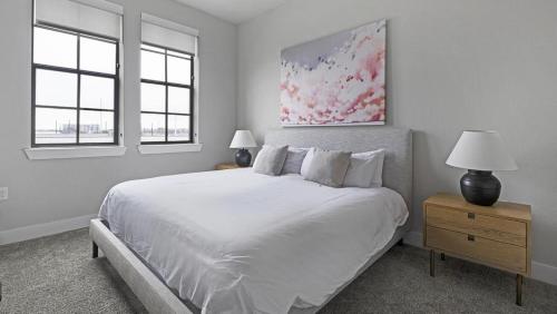 1 dormitorio blanco con 1 cama grande y 2 ventanas en Landing - Modern Apartment with Amazing Amenities (ID1403X351), en Houston