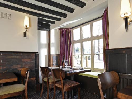 una sala da pranzo con tavolo, sedie e finestra di The Red Lion Hotel a Cambridge