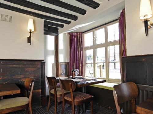 ケンブリッジにあるThe Red Lion Hotelのテーブルと椅子と窓のあるダイニングルーム
