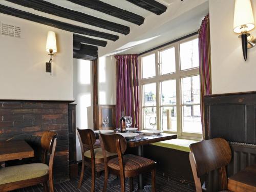 comedor con mesa, sillas y ventana en The Red Lion Hotel, en Cambridge