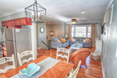a kitchen and living room with a table and a refrigerator at Gorgeous beach house with large pool & private beach, just 3 blocks away!! in Point Pleasant Beach