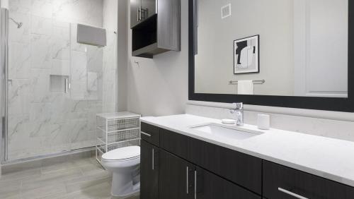 bagno bianco con servizi igienici e lavandino di Landing - Modern Apartment with Amazing Amenities (ID1403X354) a Houston