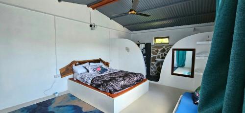 ein Schlafzimmer mit einem Bett in der Mitte eines Zimmers in der Unterkunft Le lataniers in Rodrigues Island