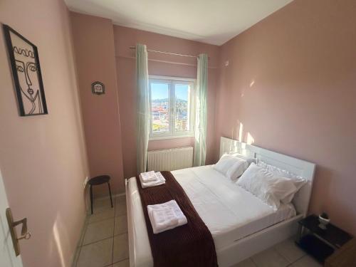 een kleine slaapkamer met een bed en een raam bij AKTIS apartment near airport in Artemida