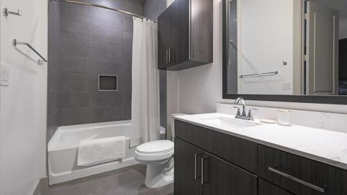 a bathroom with a sink and a toilet and a bath tub at Landing - Modern Apartment with Amazing Amenities (ID1403X401) in Houston