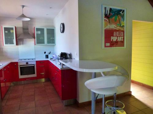 een keuken met rode en gele kasten en een tafel bij Villa d'une chambre avec piscine privee terrasse et wifi a La Riviere Saint Louis a 8 km de la plage in Saint-Louis