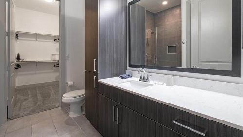 y baño con lavabo, aseo y espejo. en Landing - Modern Apartment with Amazing Amenities (ID1403X402), en Houston