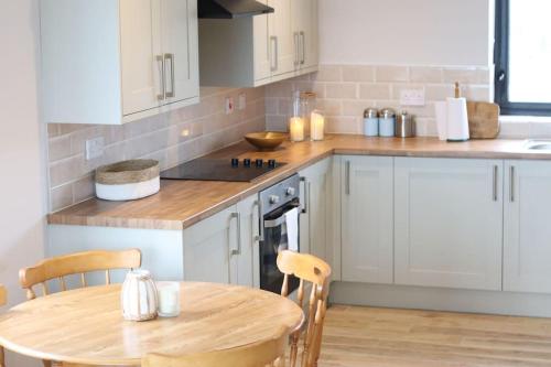 a kitchen with white cabinets and a wooden table at Lake view Dunfanaghy in Dunfanaghy