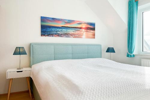 a bedroom with a bed and a painting on the wall at Haffblick Wohnung 65 in Boltenhagen
