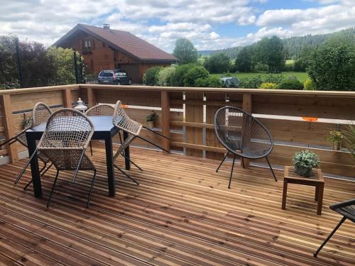 eine Terrasse mit einem Tisch und Stühlen auf einer Terrasse in der Unterkunft Le cocon du rondeau(gîte cosy) in Labergement-Sainte-Marie