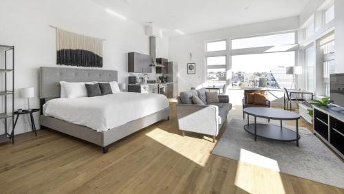 um quarto com uma cama e uma sala de estar em Landing - Modern Apartment with Amazing Amenities (ID1401X734) em Denver