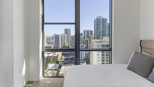 een witte slaapkamer met uitzicht op de stad bij Landing - Modern Apartment with Amazing Amenities (ID1401X726) in Fort Lauderdale