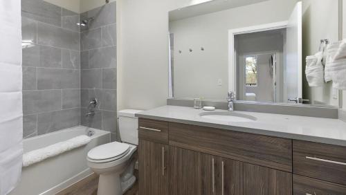 W łazience znajduje się umywalka, toaleta i wanna. w obiekcie Landing - Modern Apartment with Amazing Amenities (ID1403X372) w mieście Portland