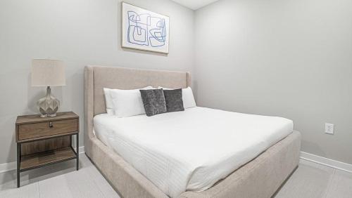 a white bedroom with a bed and a night stand at Landing - Modern Apartment with Amazing Amenities (ID1402X986) in Birmingham