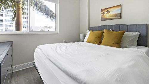 um quarto com uma grande cama branca com almofadas amarelas em Landing - Modern Apartment with Amazing Amenities (ID1403X559) em St. Petersburg
