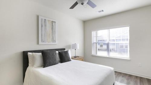 a white bedroom with a bed and a window at Landing - Modern Apartment with Amazing Amenities (ID1401X786) in Fort Worth